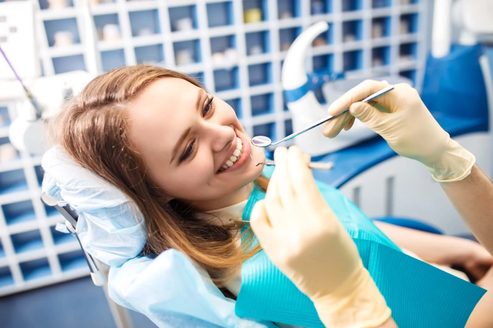 Dentist examining patient's smile during restorative dental appointment